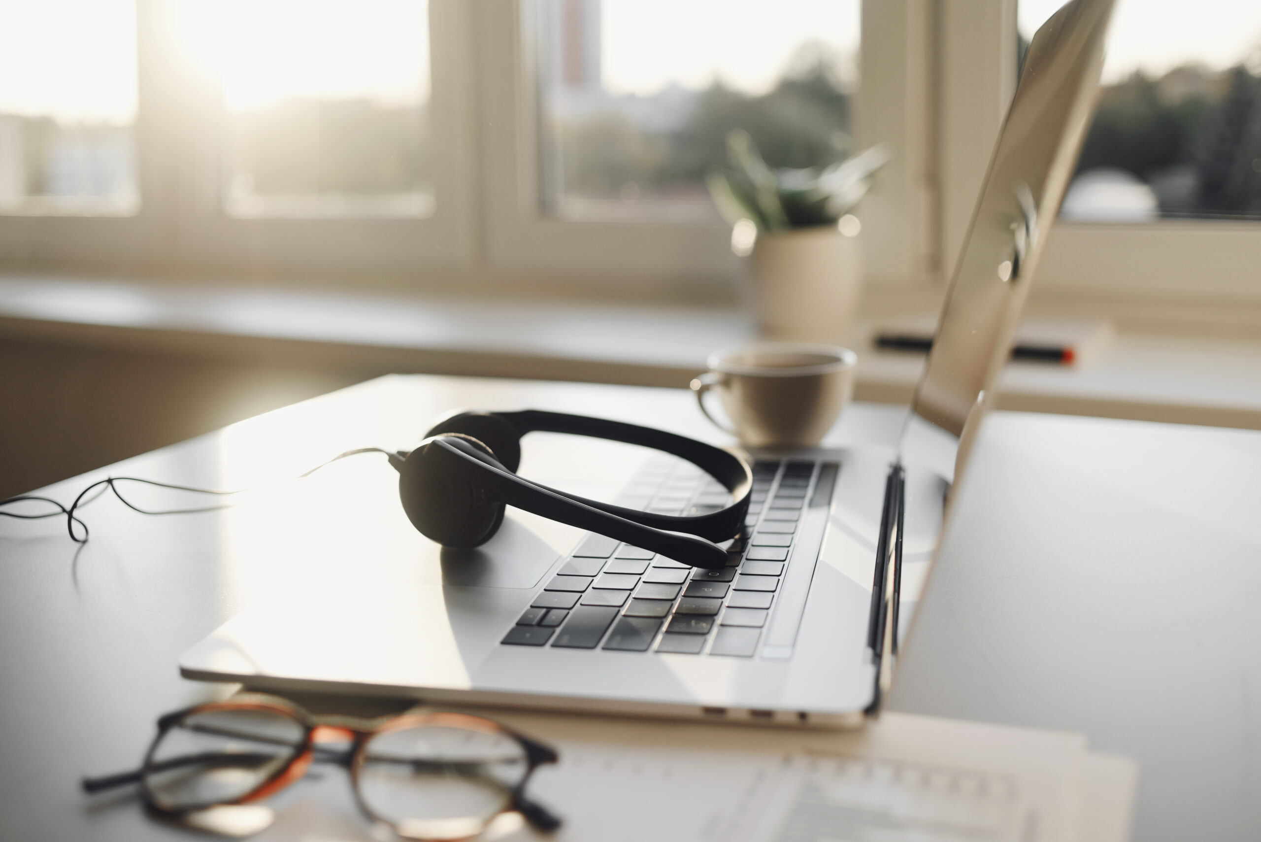 Work place in office, headset, laptop computer, glasses at office desk